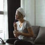 Woman applying a facial on her couch