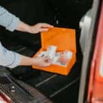 Young woman using car first aid kit box