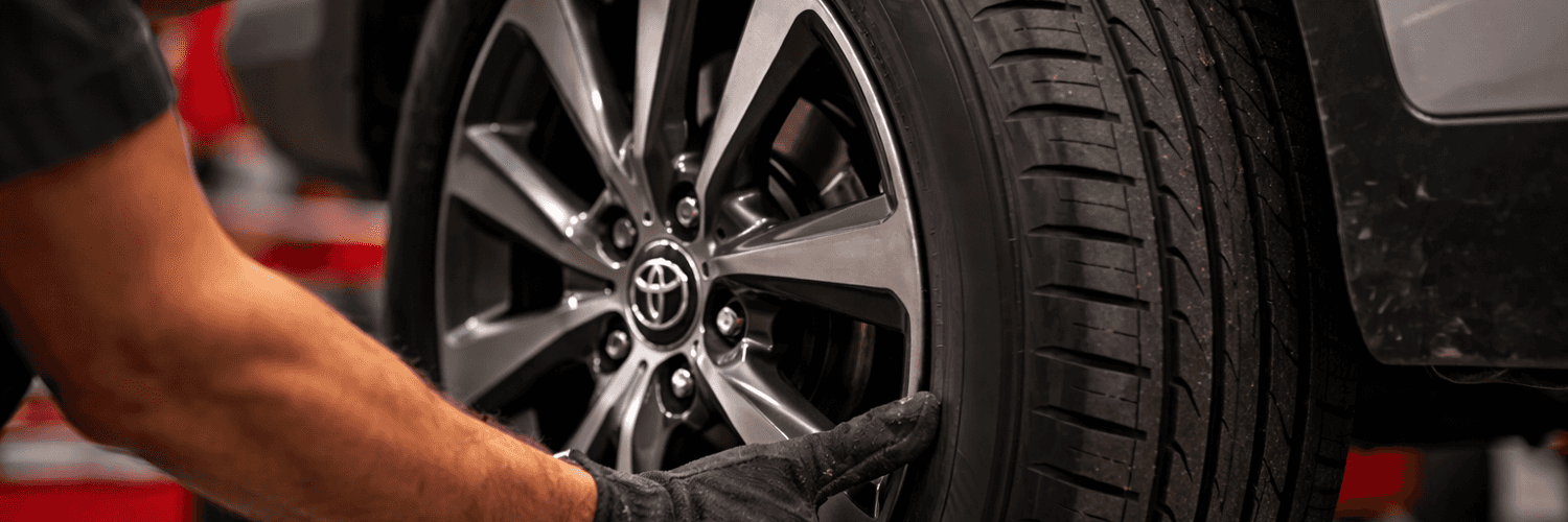 Red vehicle driving through wet road conditions that show how tire traction matters