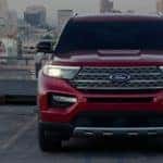 a red ford explorer is parked on a rooftop in front of a city