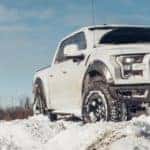 a white truck parked up on a snow bank